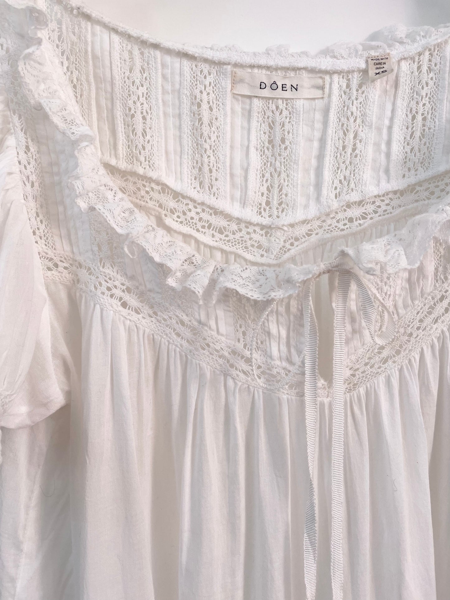 Close up of lace trimming on white cotton DÔEN dress